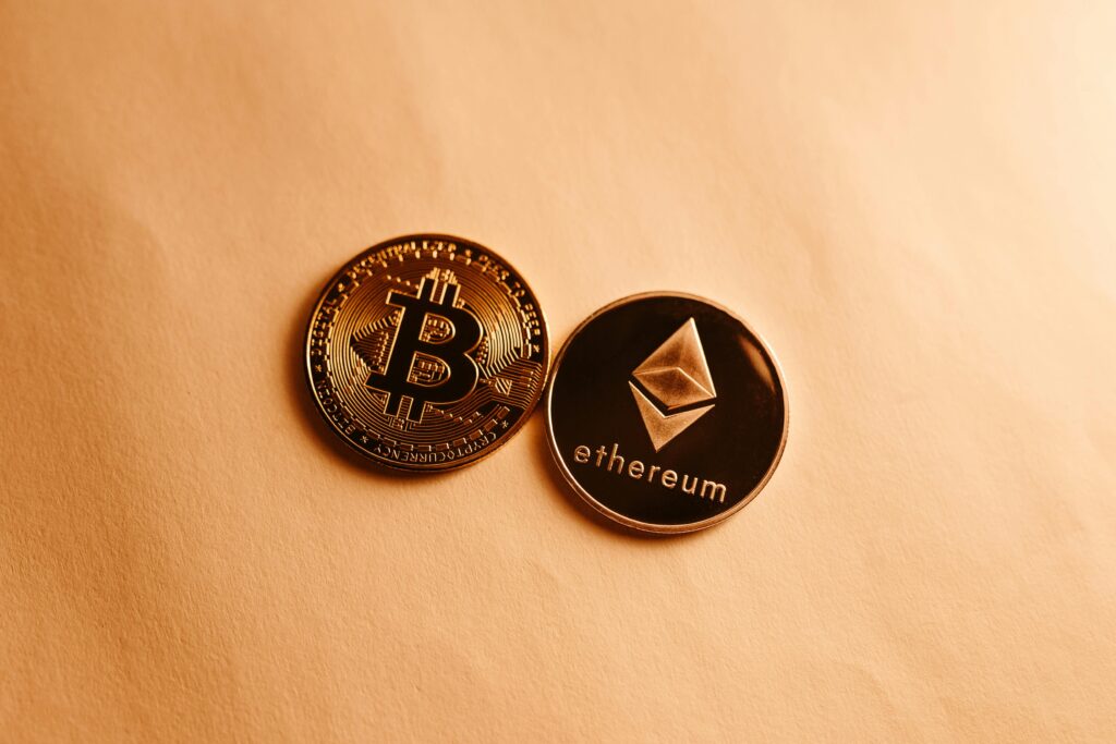 Bitcoin and Ethereum coins depicted on a soft yellow background for cryptocurrency and finance themes.